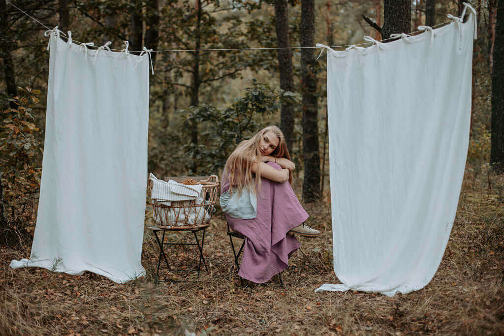 Linen curtain panels hanging asymmetrically at window, natural drape and weight