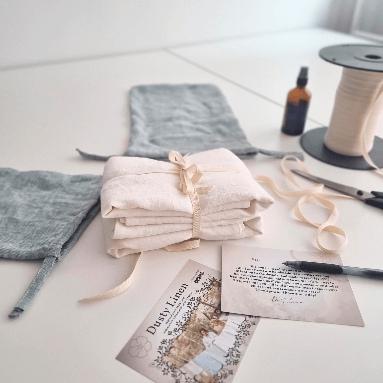 Linen fabric samples and sewing tools arranged on a worktable