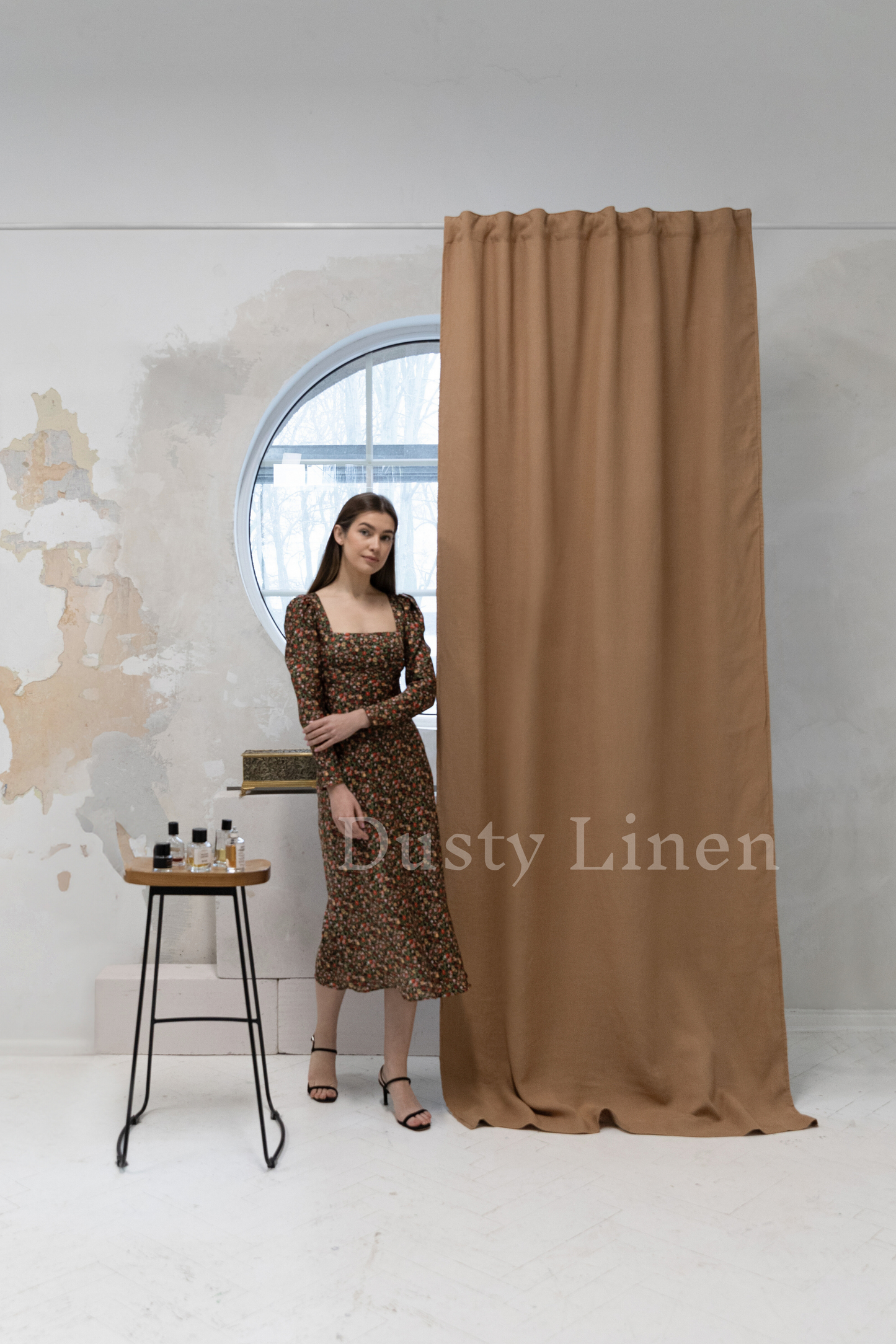 a woman standing in front of a curtain