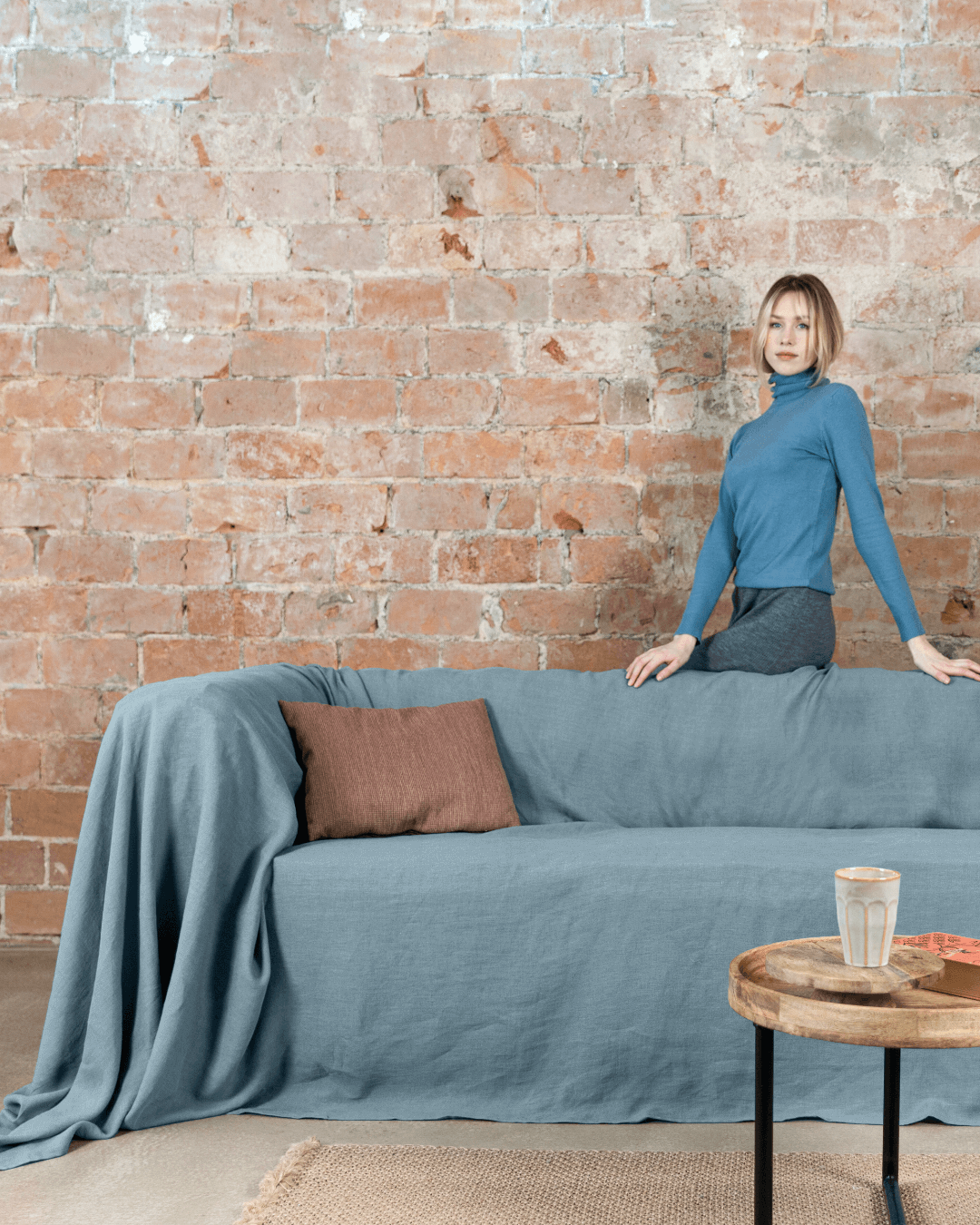 a woman standing on top of a blue couch