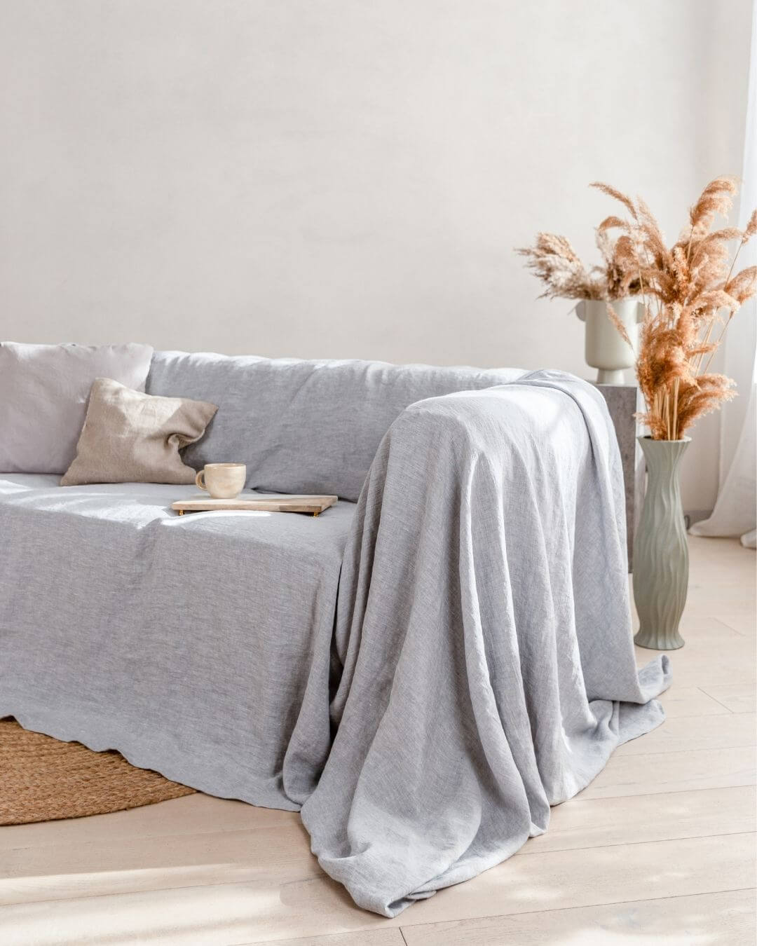 a living room with a couch covered in a light gray linen blanket