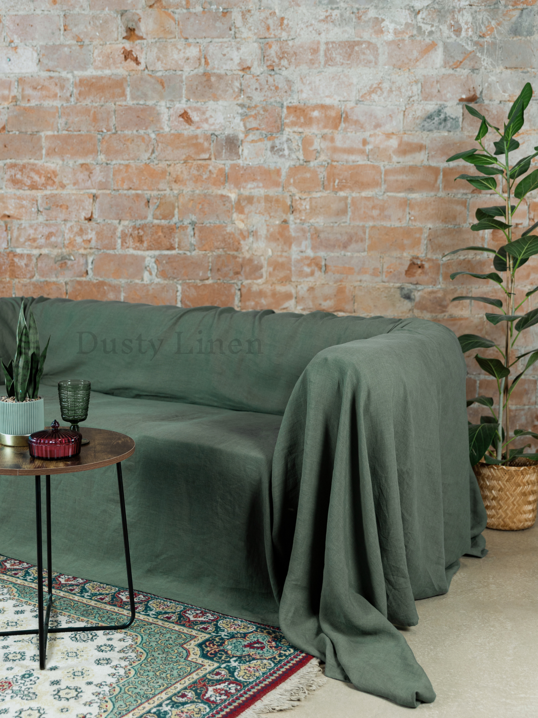 a living room with a brick wall and a green couch