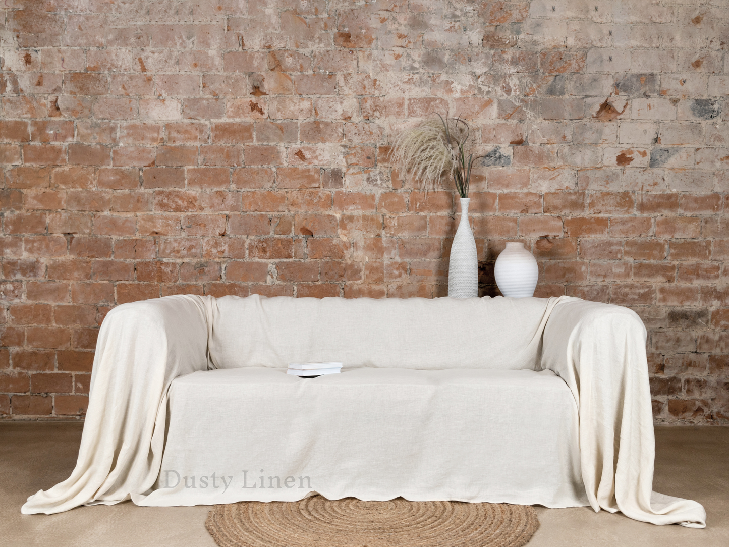 a white couch sitting in front of a brick wall