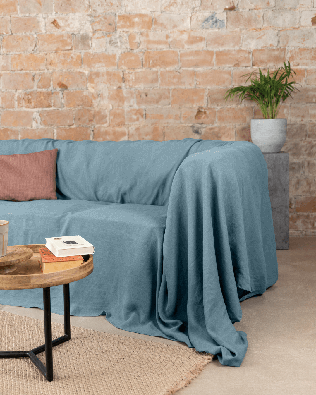 a living room with a couch, coffee table and a brick wall
