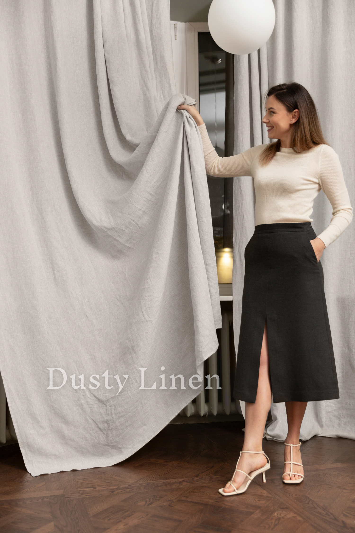 a woman holding a white ball in front of a curtain