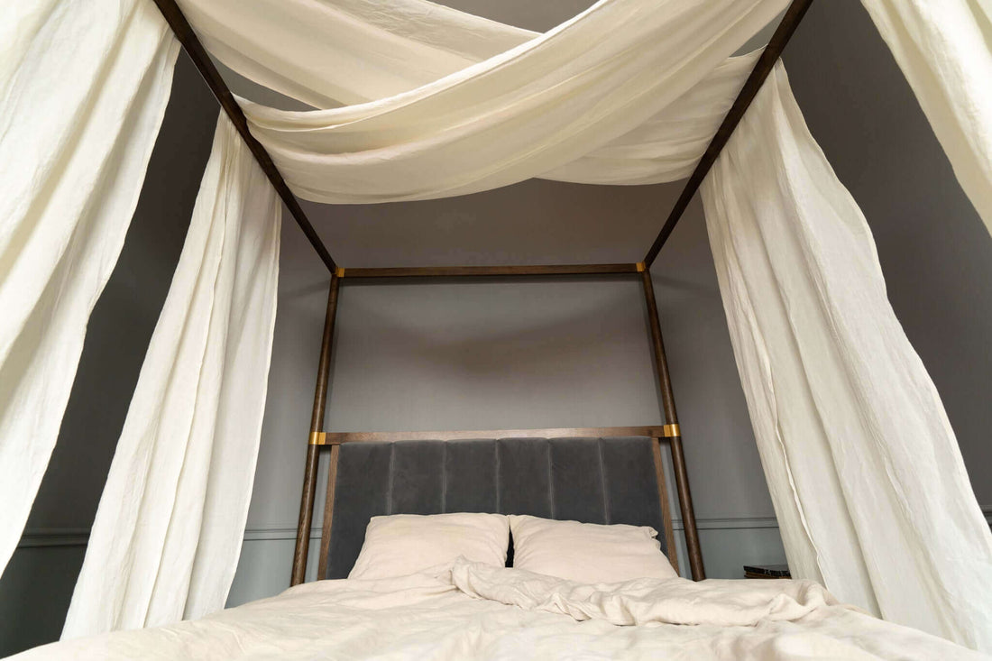 Linen canopy bed curtains on four-poster bed, inspired by ancient linen tradition