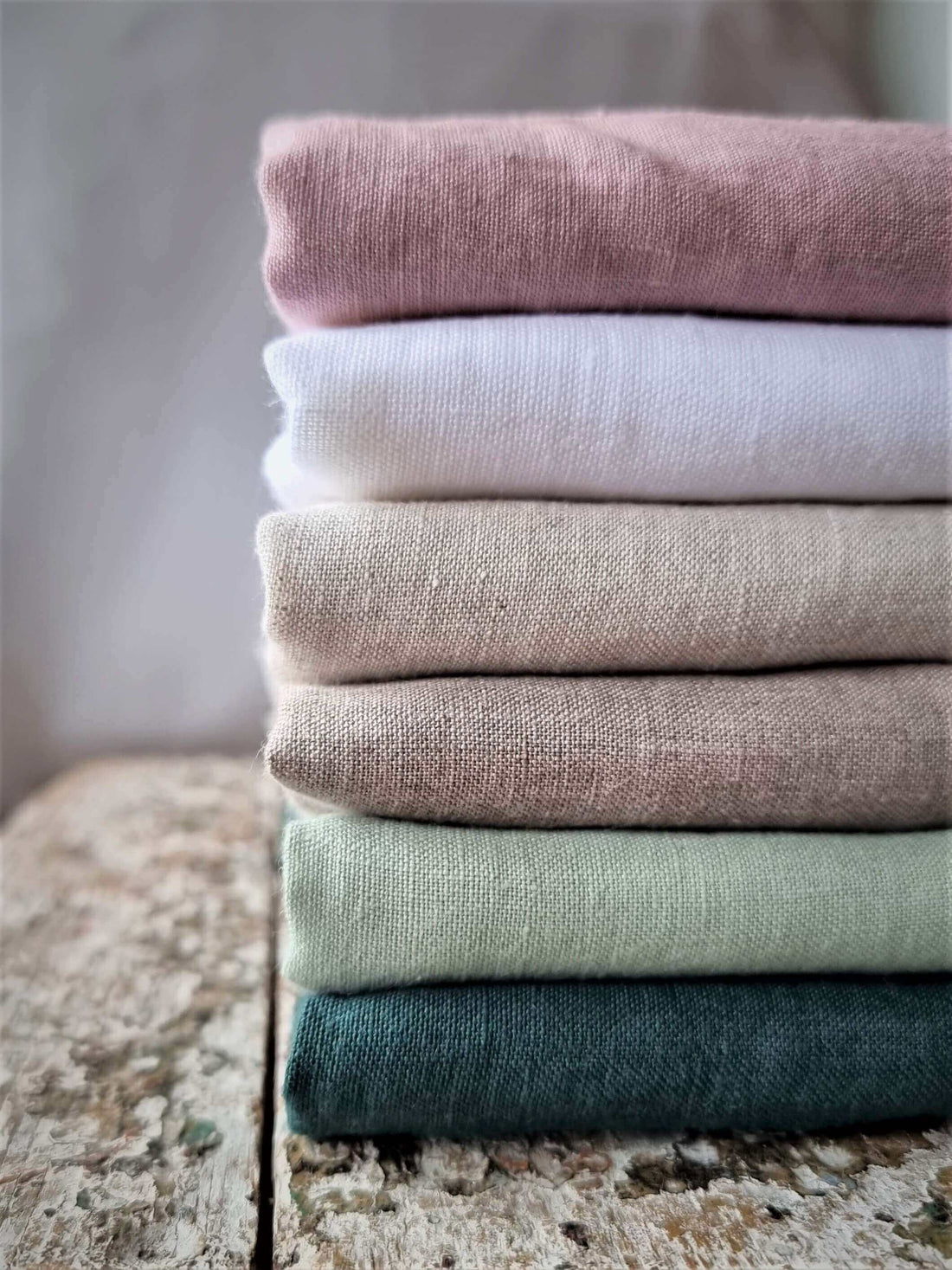 Linen  - natural linen fabrics stacked on wooden surface