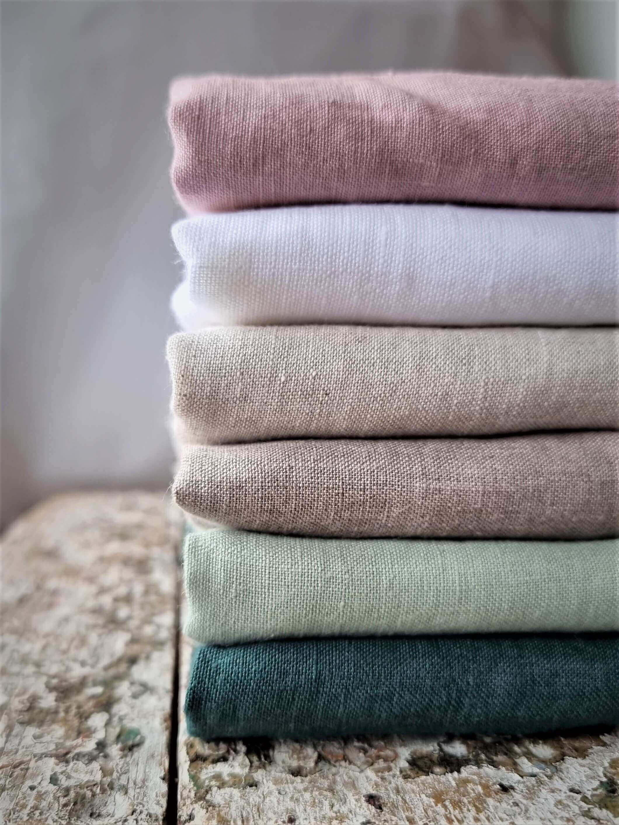 Linen  - natural linen fabrics stacked on wooden surface