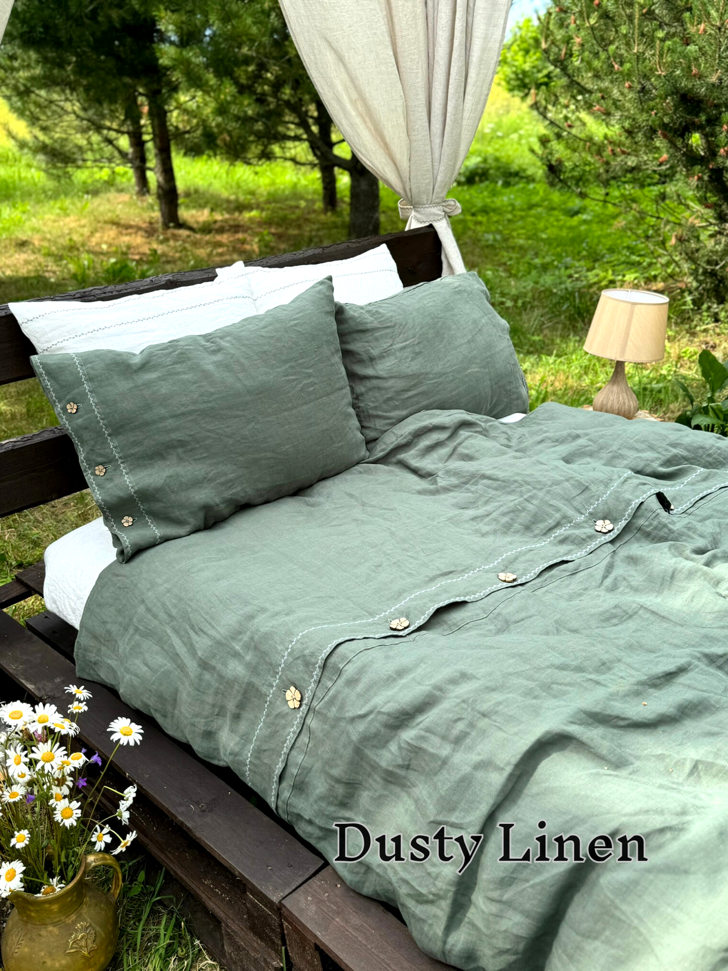 a bed sitting in the middle of a lush green field
