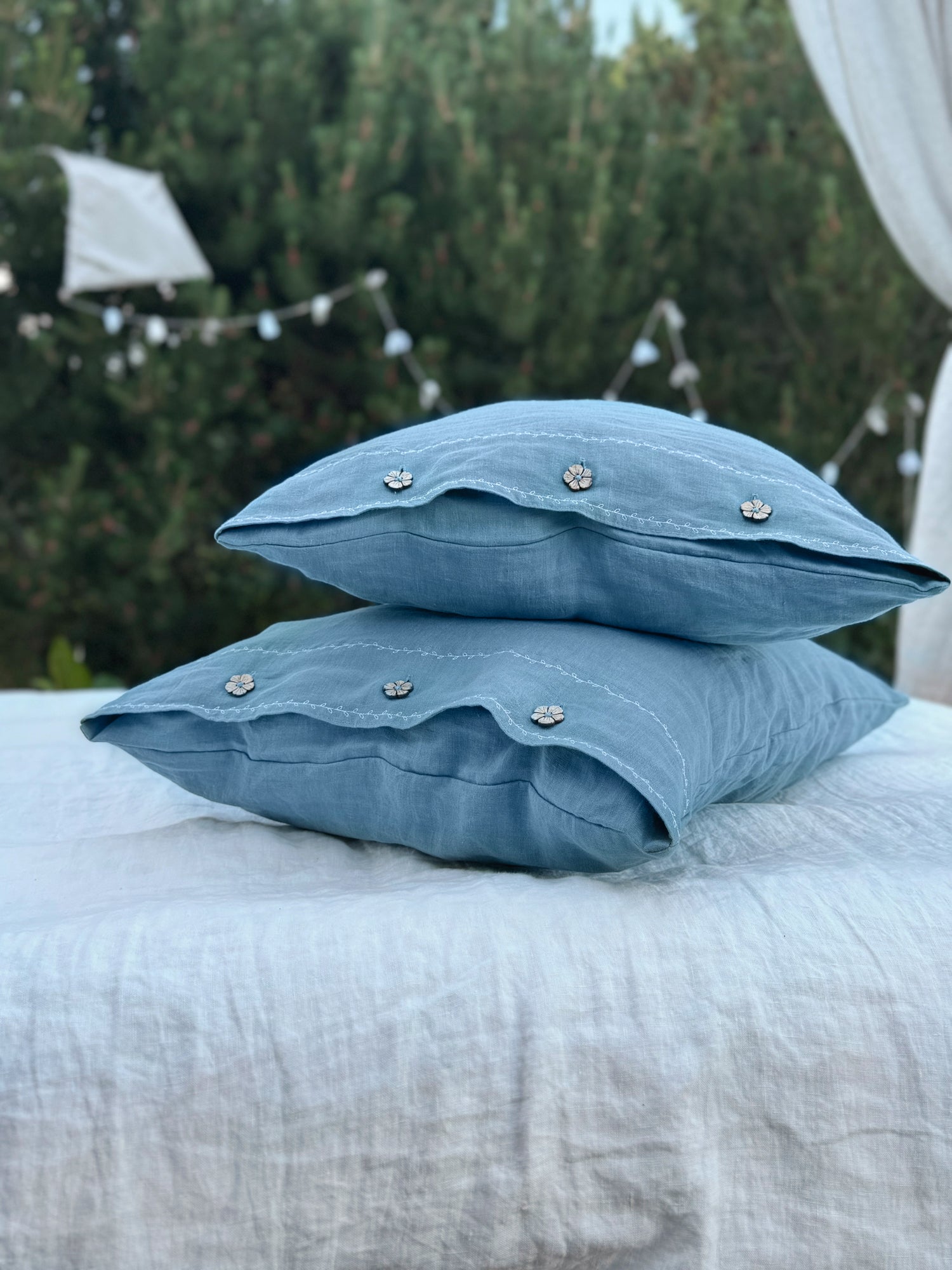 a pair of blue pillows sitting on top of a bed