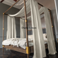 a four poster bed with white drapes on top of it