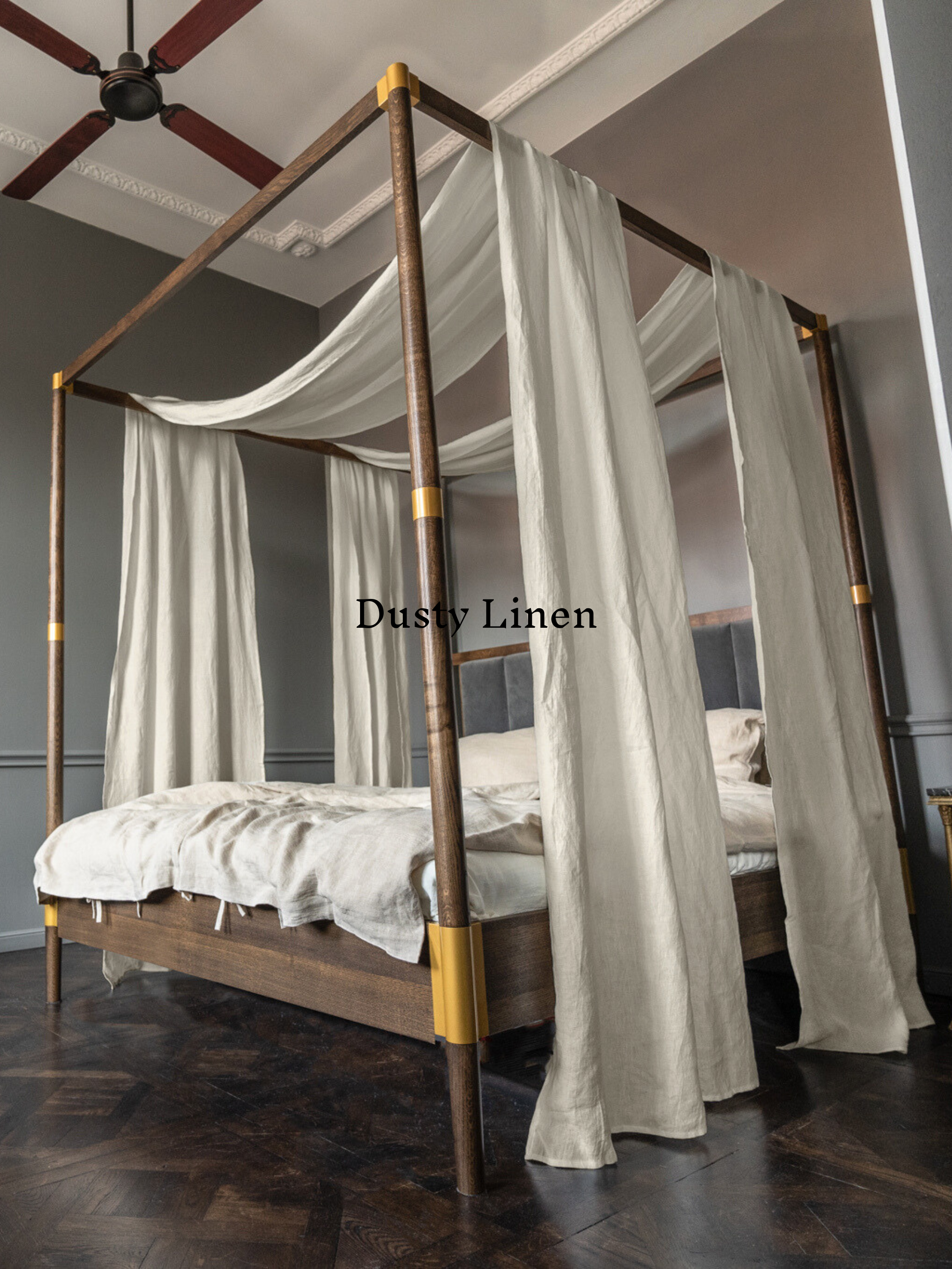 a four poster bed with white drapes on top of it