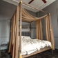 a bed with a canopy in a room with a ceiling fan