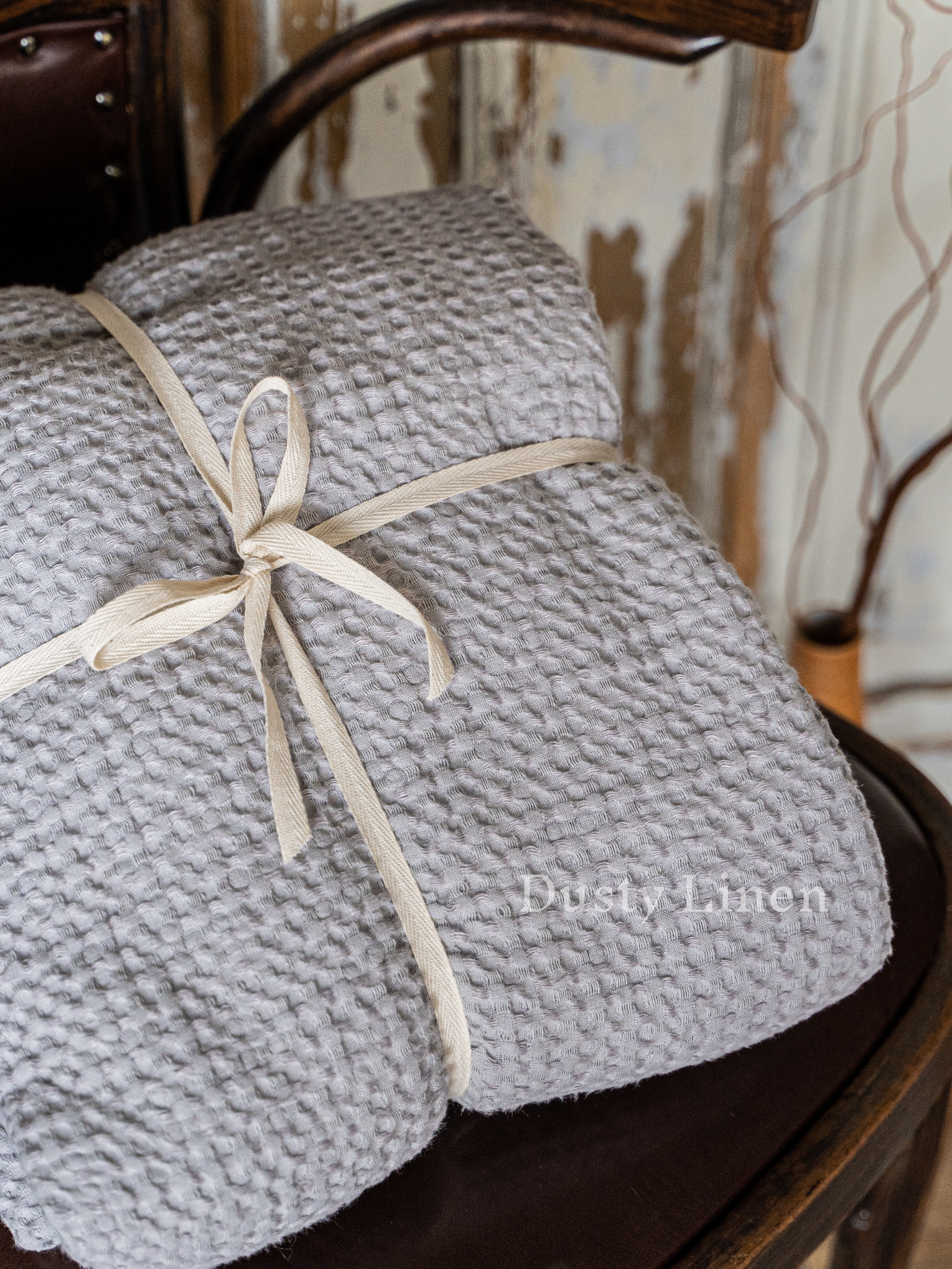 a stack of gray blankets tied with a white ribbon