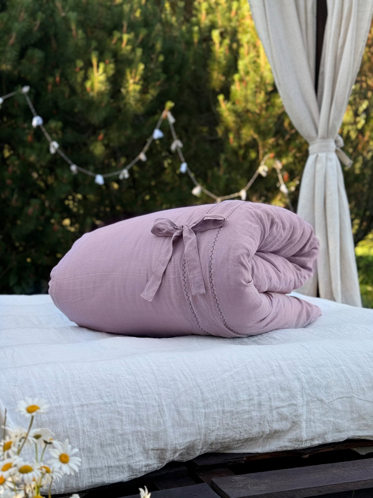 a pink pillow sitting on top of a white bed