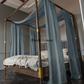 a four poster bed with blue drapes on it