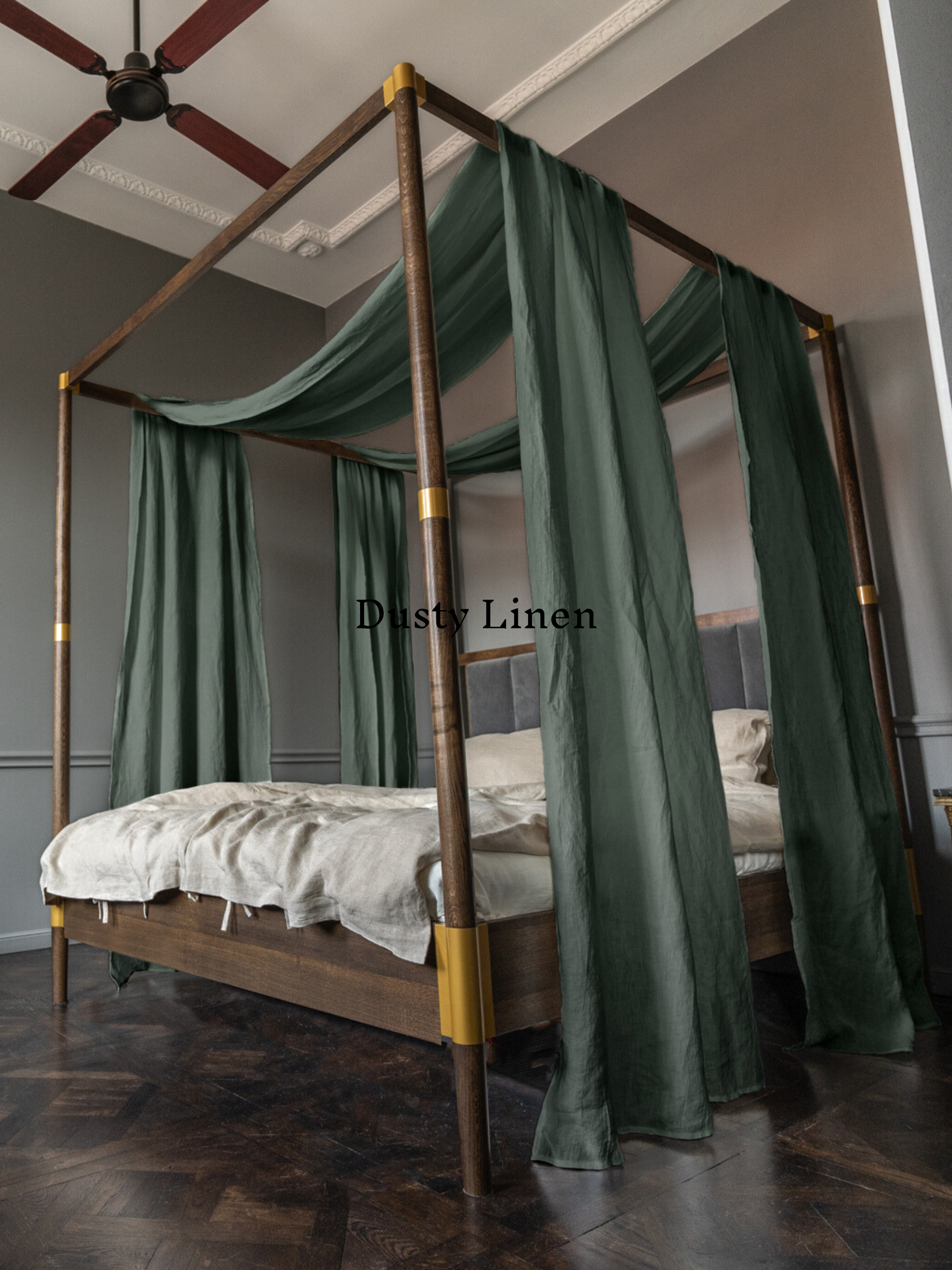 a four poster bed with green drapes on it