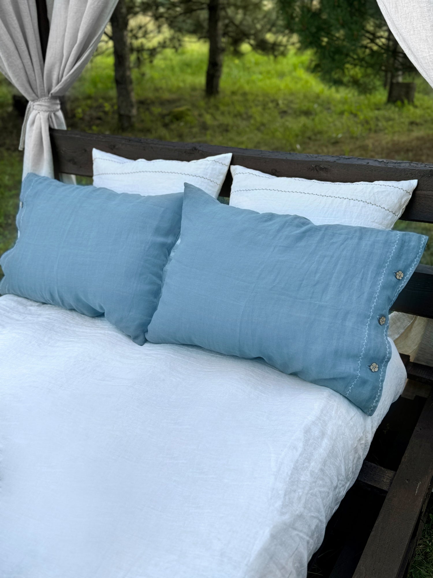 a bed with two blue pillows and a white blanket