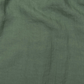 a close up of a green cloth with a black dot on it