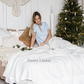 a woman sitting on a bed in front of a christmas tree