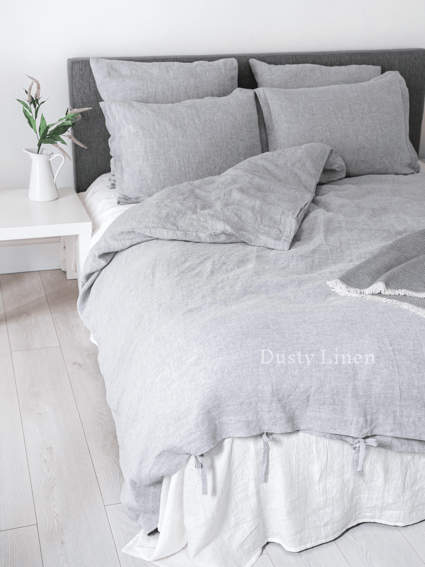 a bed with a gray comforter and pillows