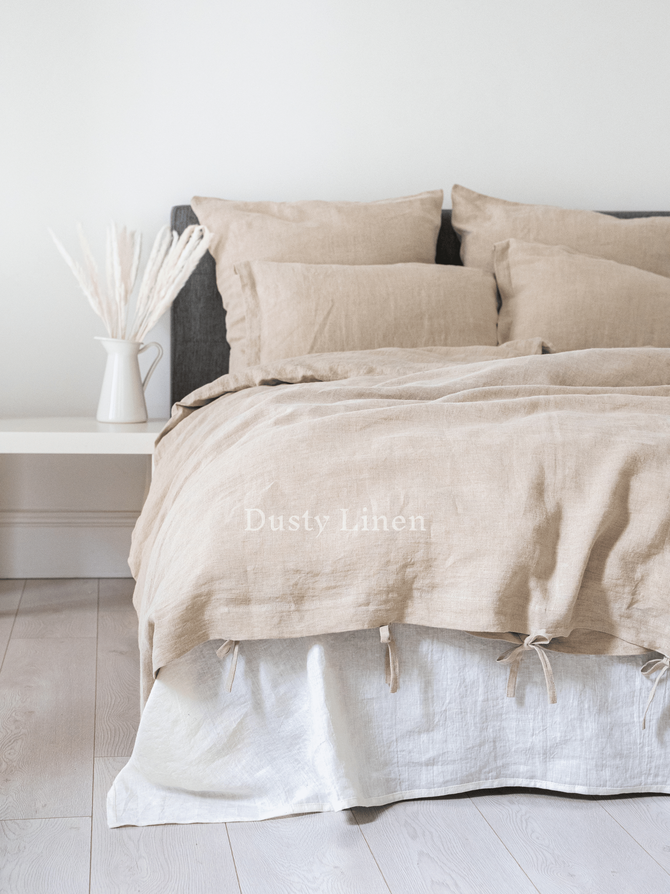 a bed that has a bunch of pillows on it