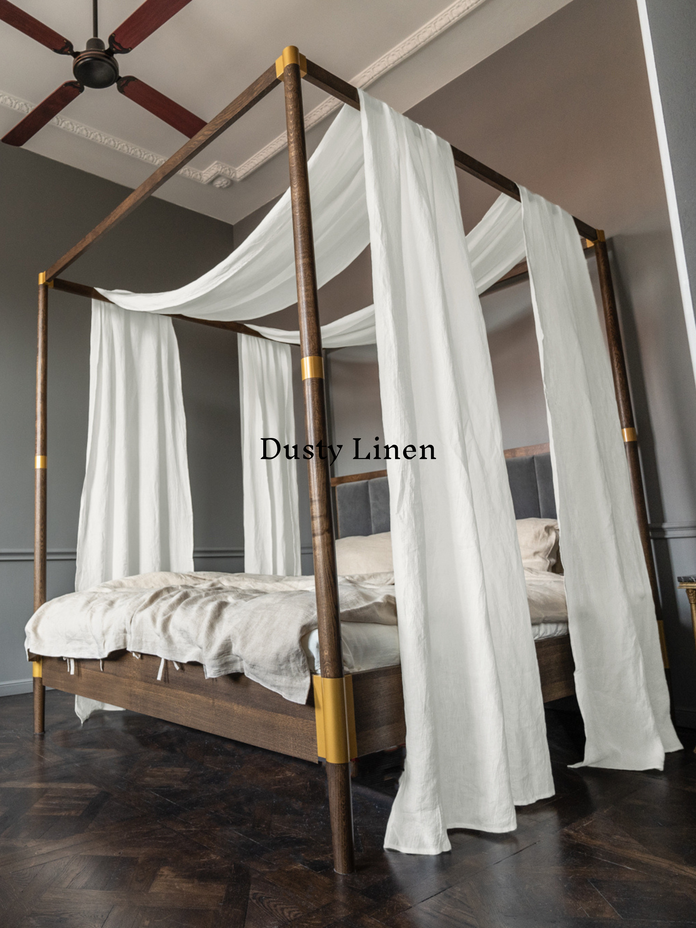 a canopy bed with white drapes and a wooden frame