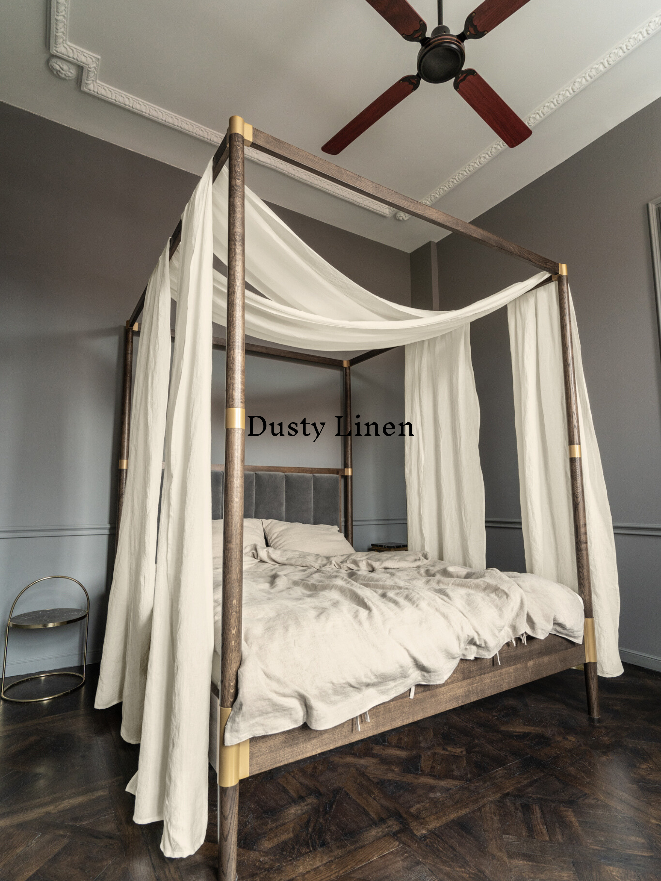 a four poster bed with white drapes and a ceiling fan