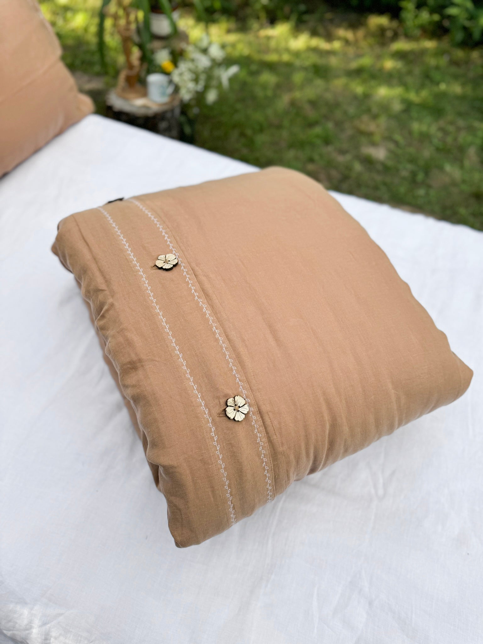 a brown pillow sitting on top of a white bed