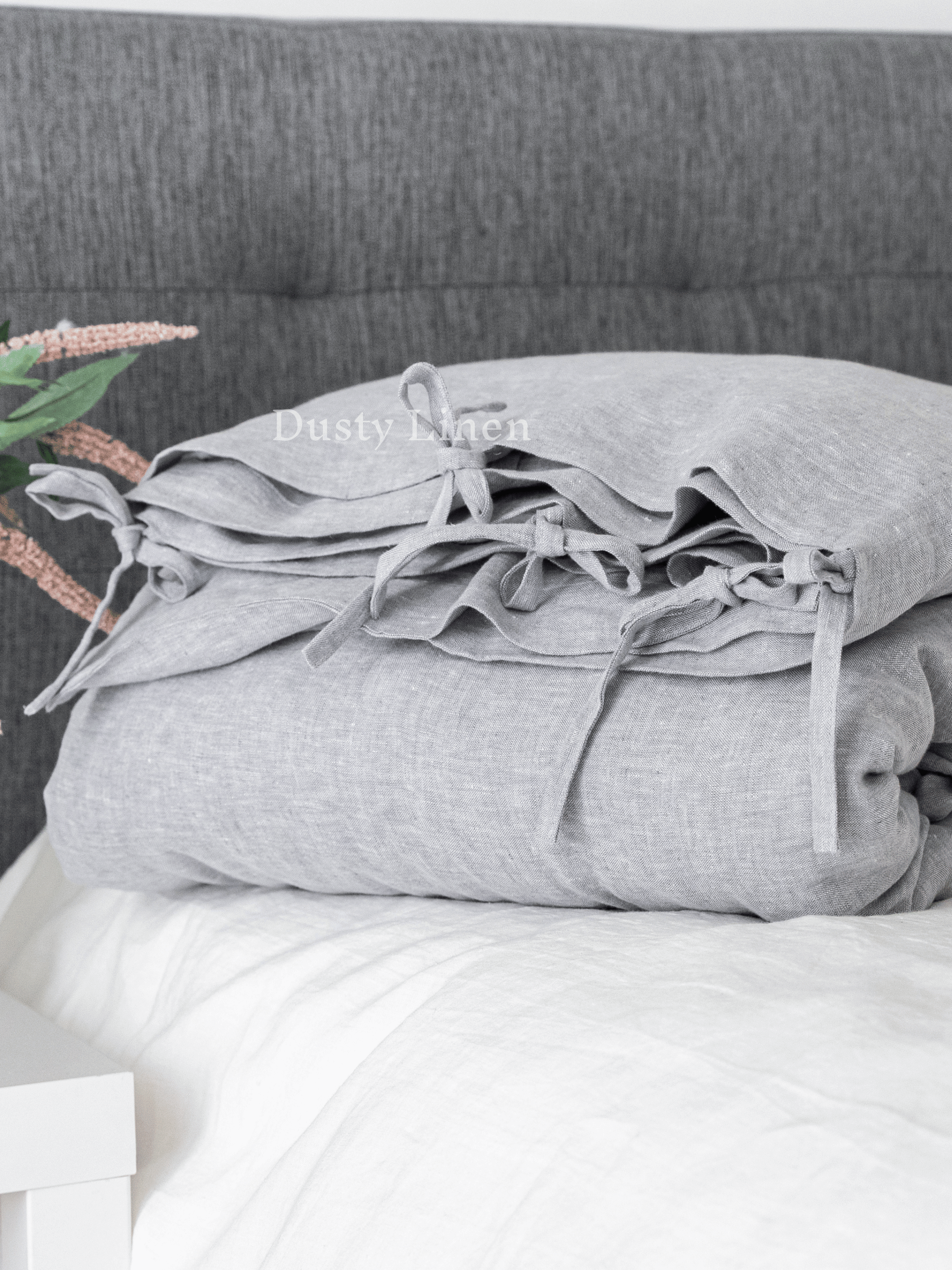 a stack of pillows sitting on top of a bed