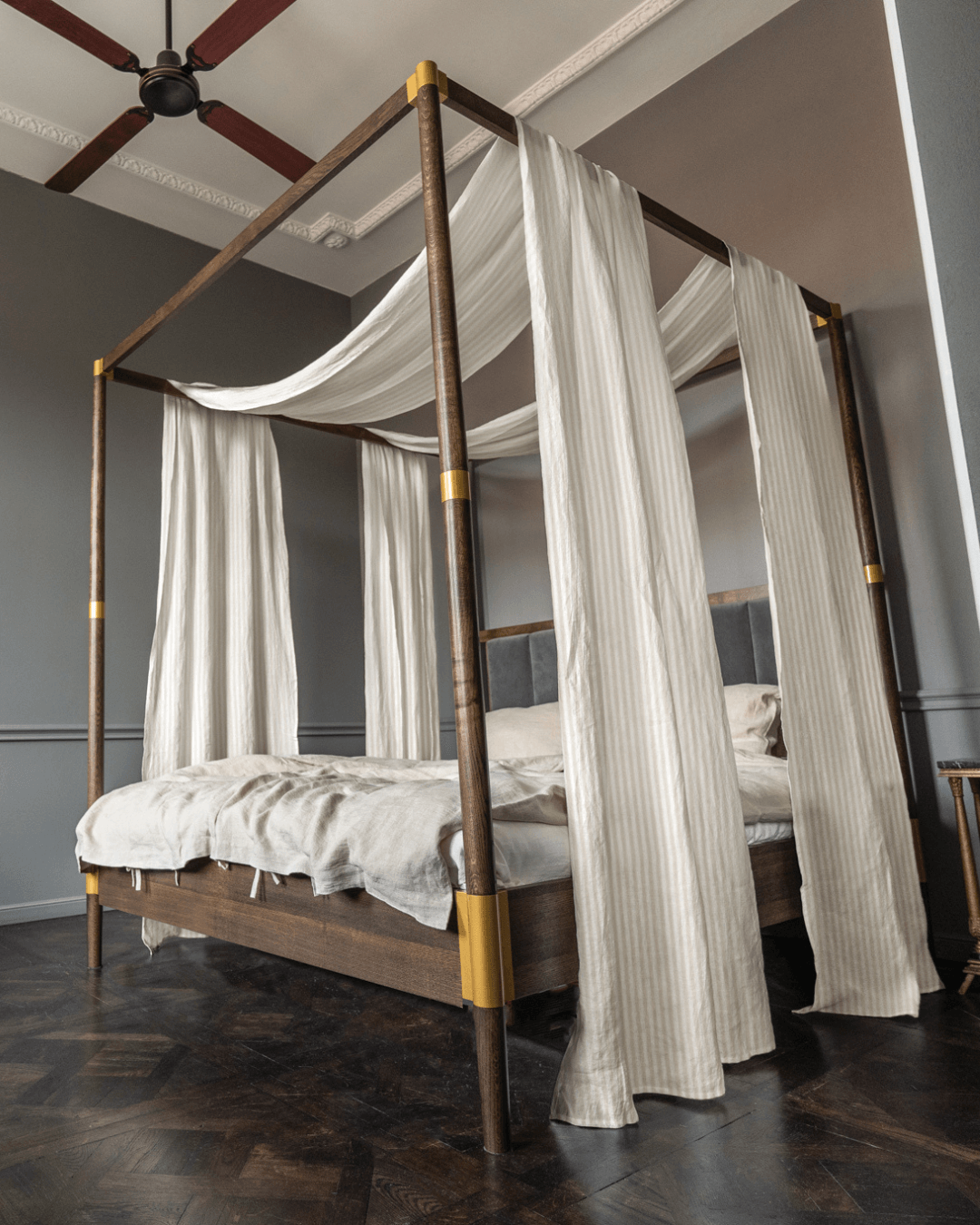 a four poster bed with white drapes on top of it