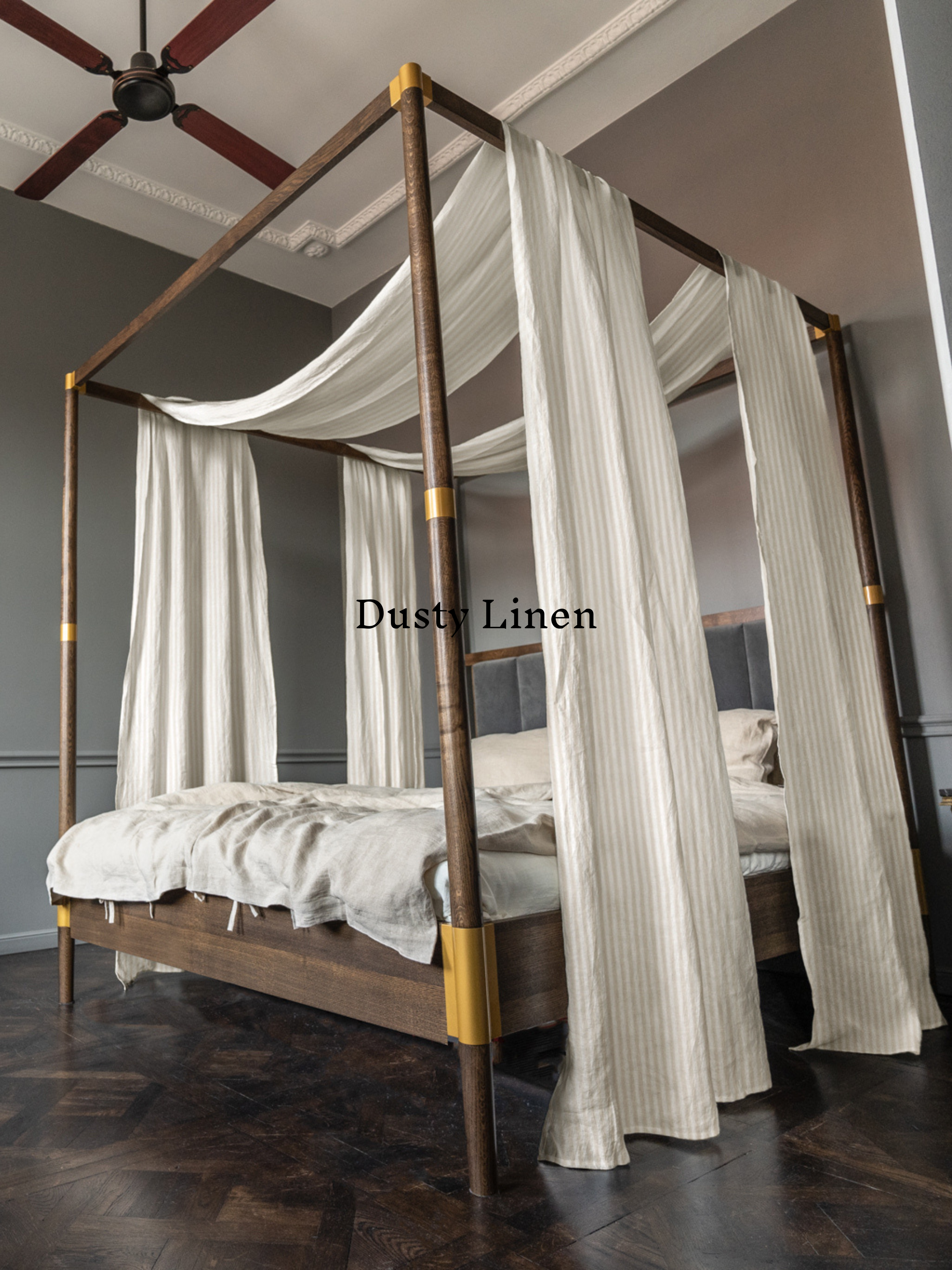 a four poster bed with white drapes on top of it