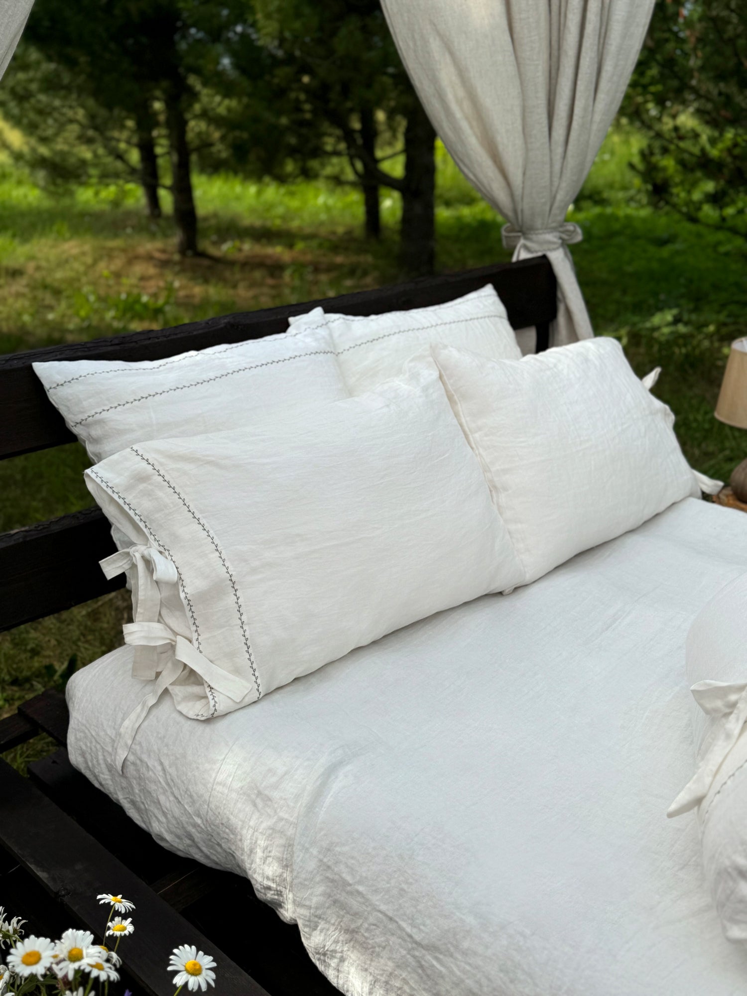 a bed with white linens and pillows on it