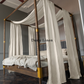 a four poster bed with white drapes on it