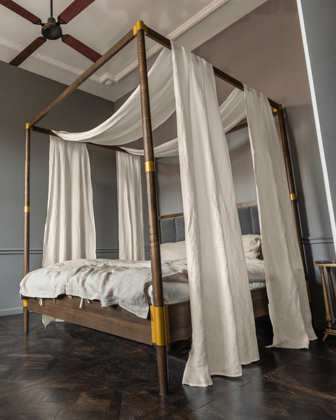 a four poster bed with white drapes on it