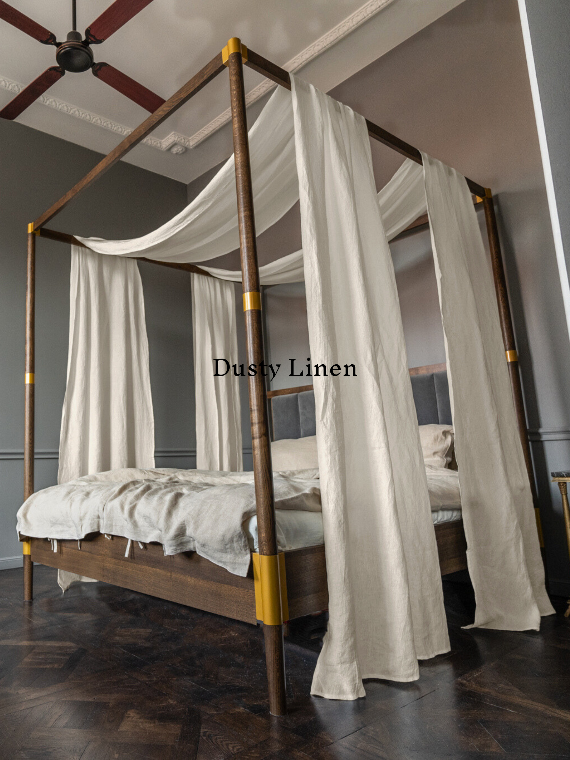 a four poster bed with white drapes on it