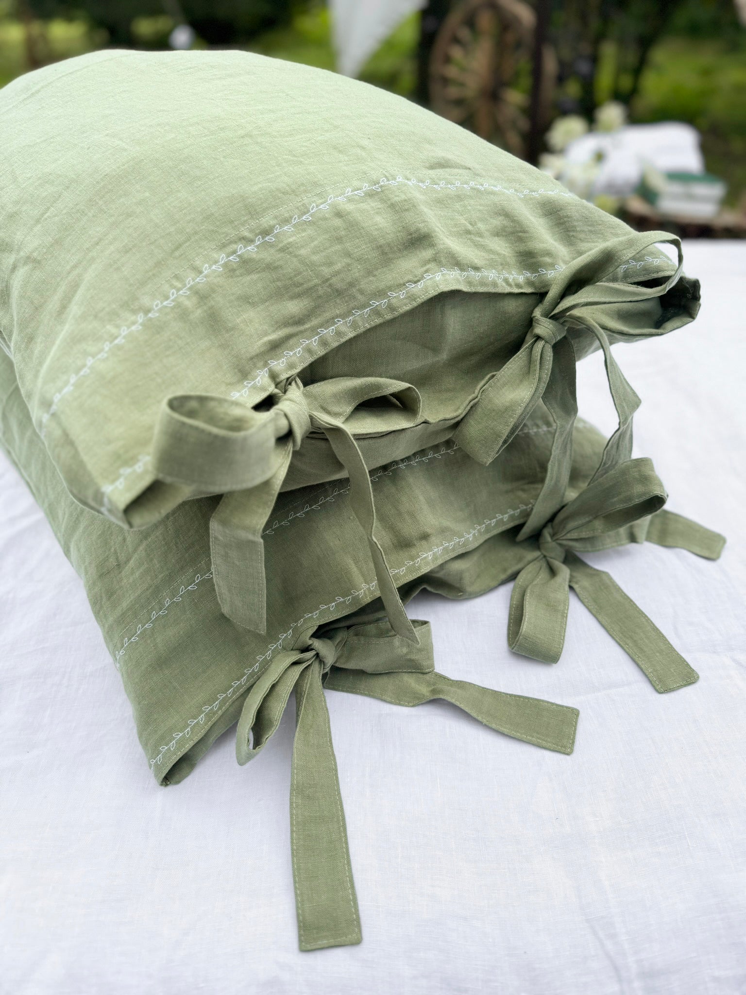 a white bed with a green pillow on top of it