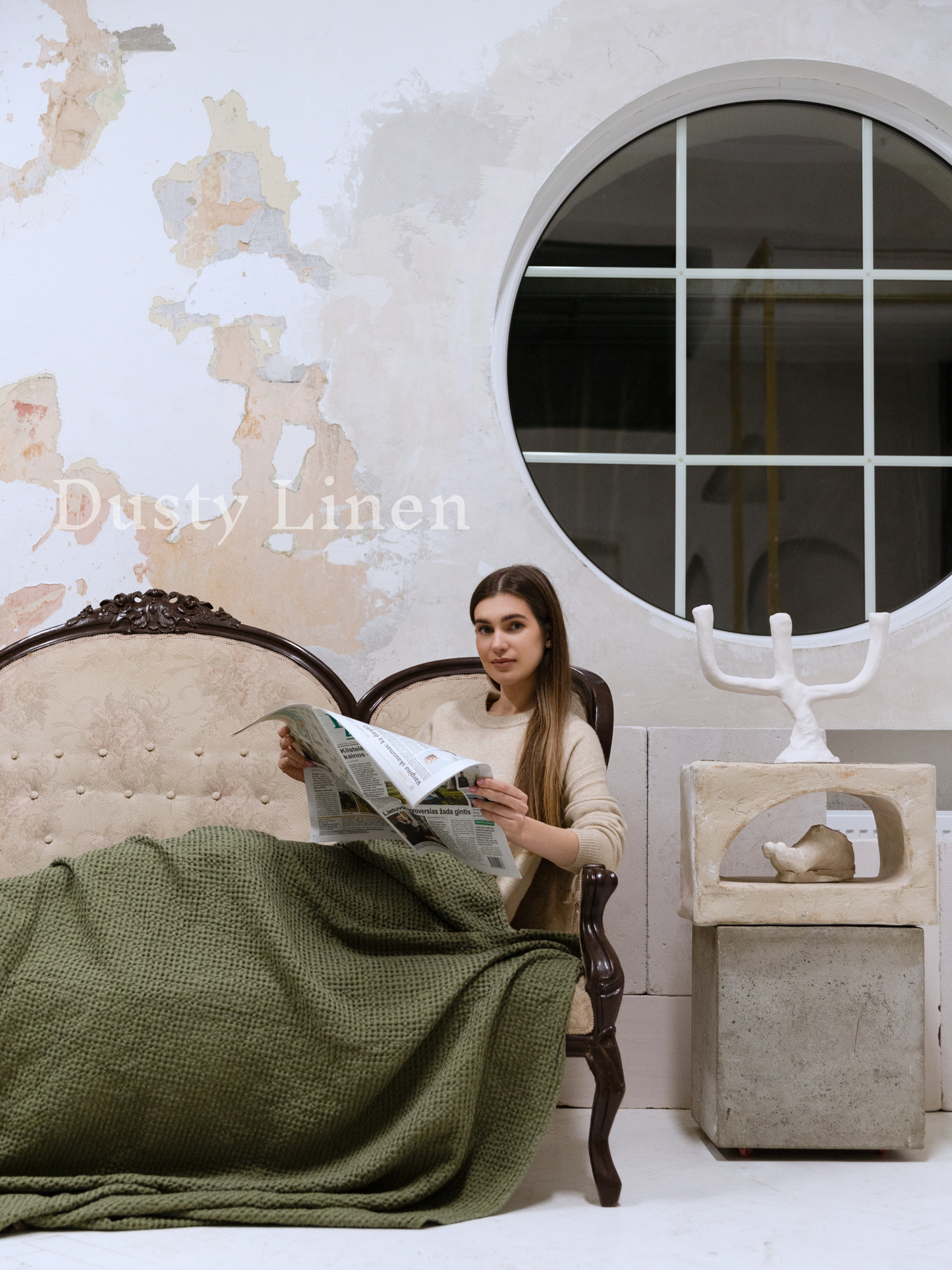 a woman sitting in a chair reading a newspaper