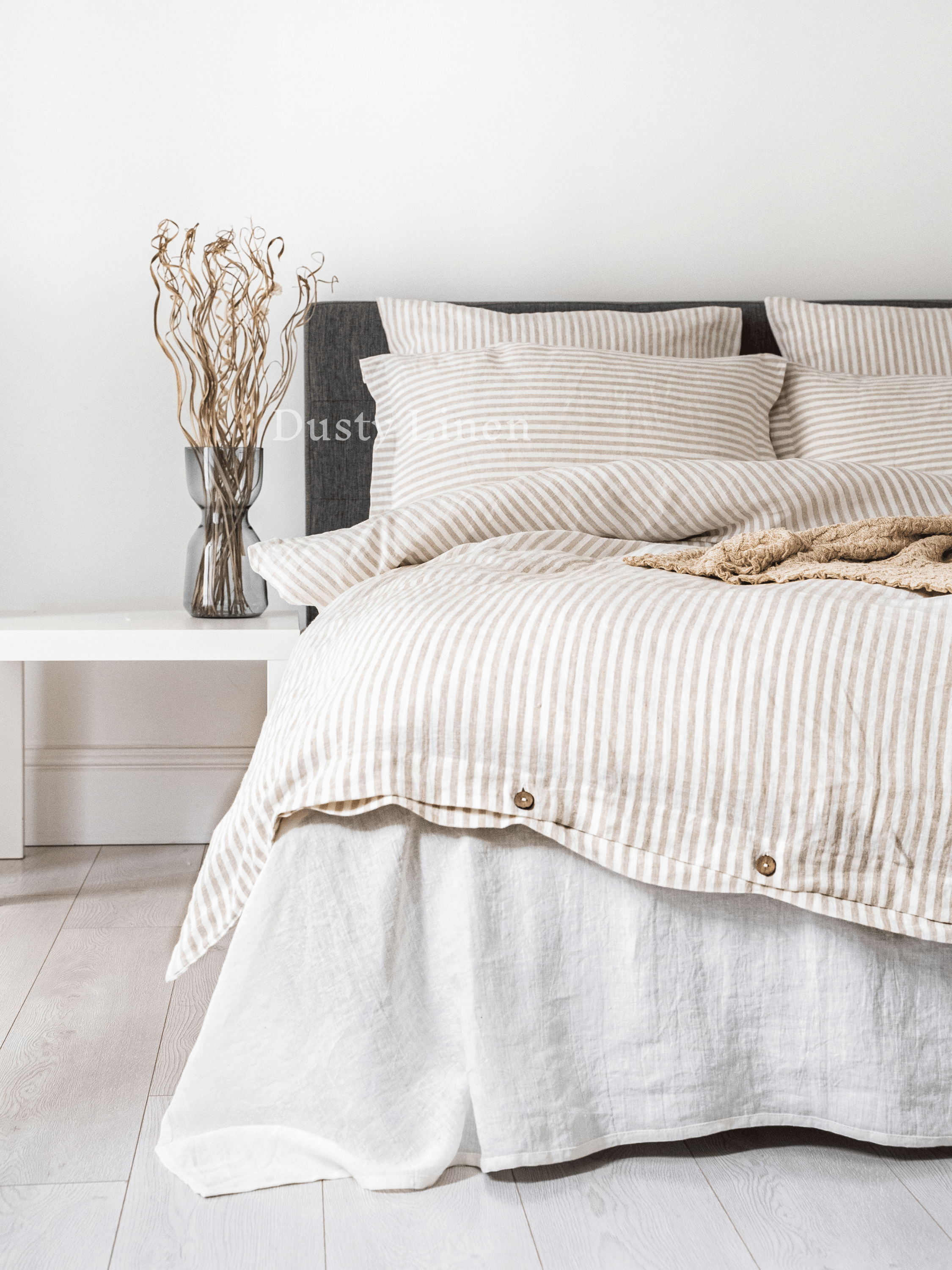 a bed with a striped comforter and pillows