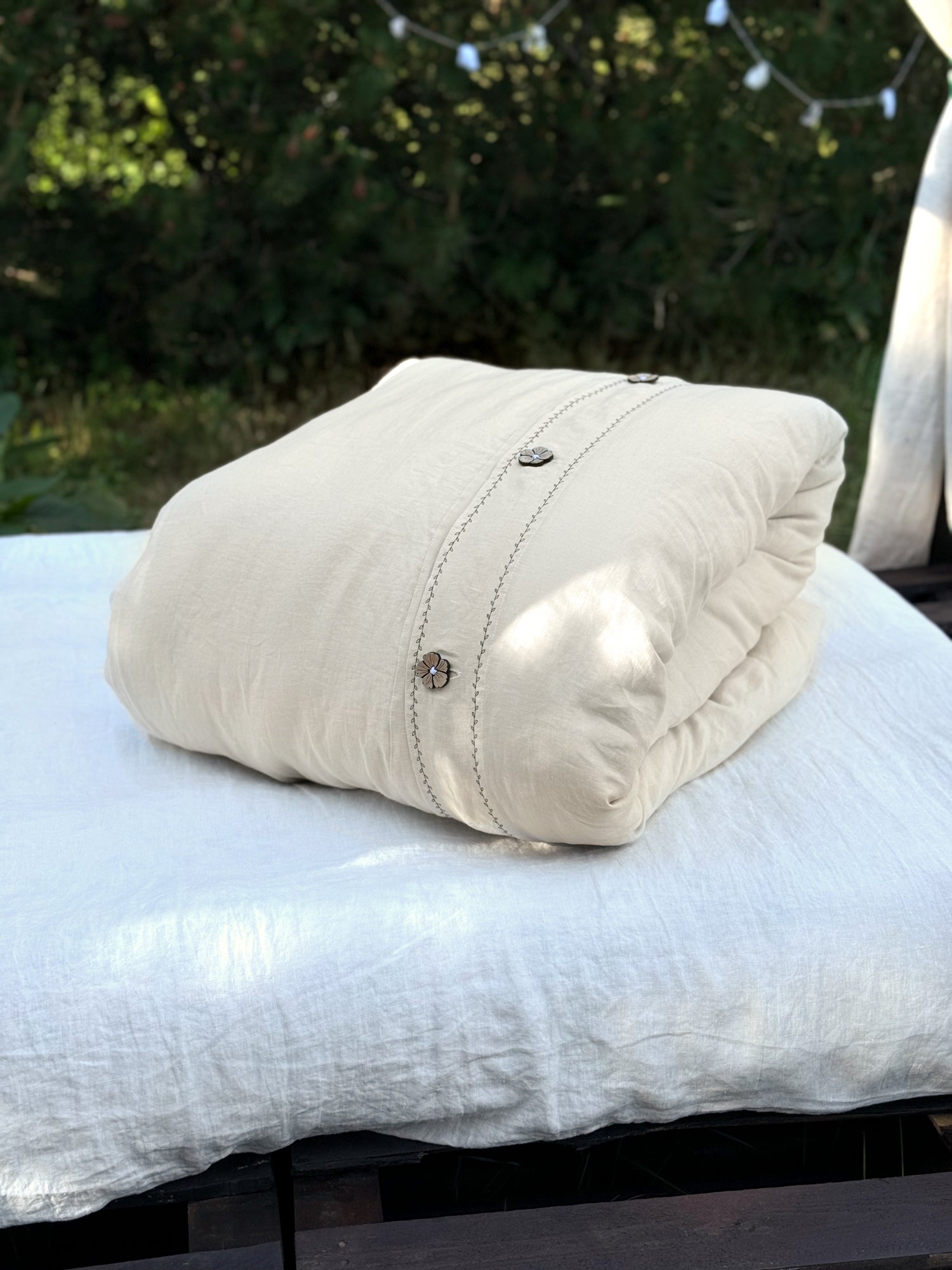 Black embroidered linen pillowcase on white bed, UK size
