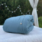 a blue pillow sitting on top of a white bed