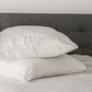 a close up of two pillows on a bed