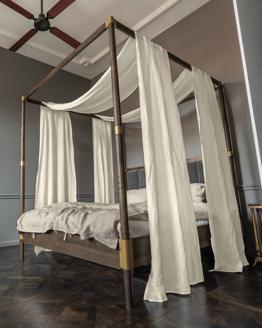 a canopy bed with white drapes on top of it