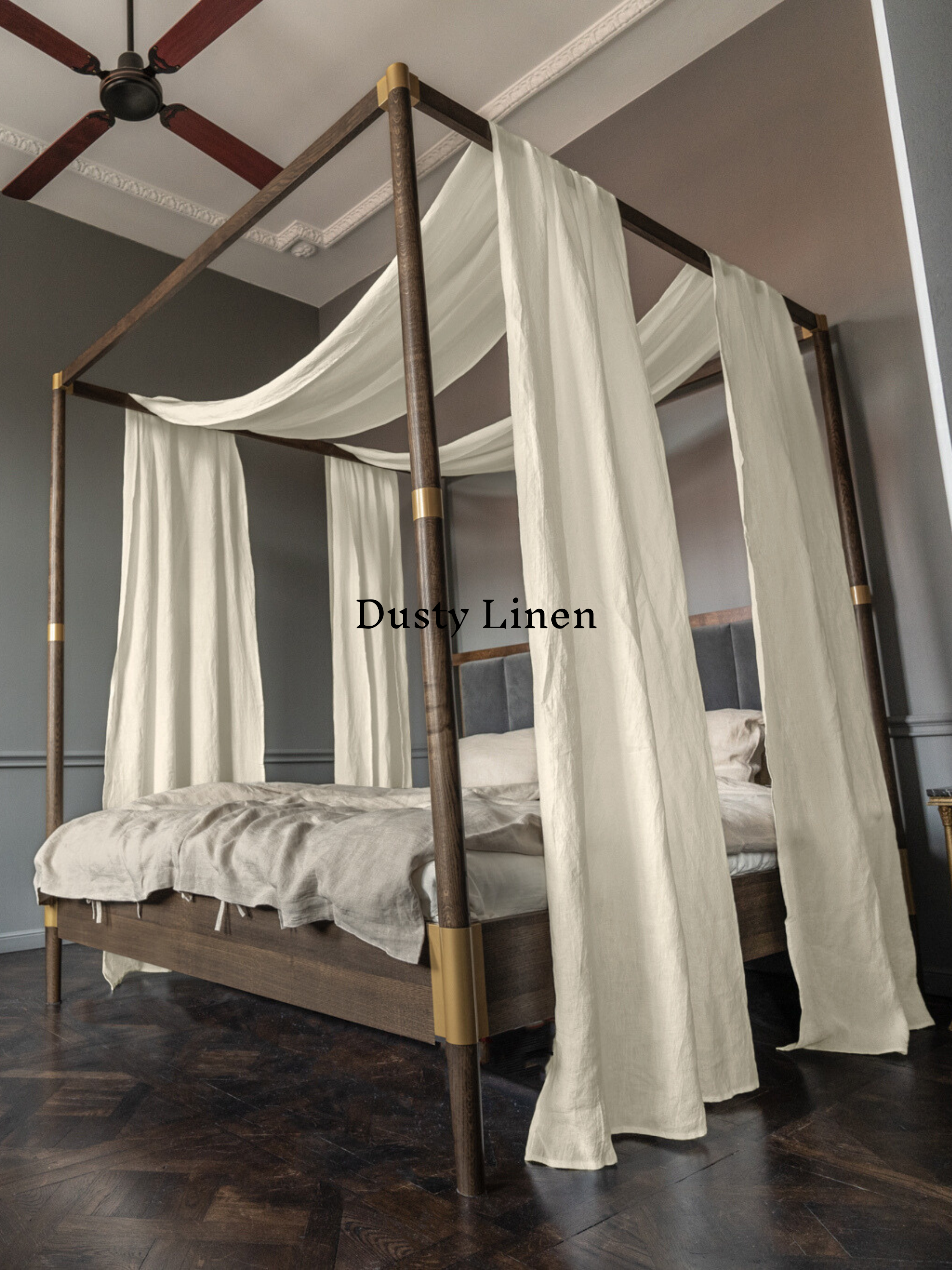 a canopy bed with white drapes on top of it