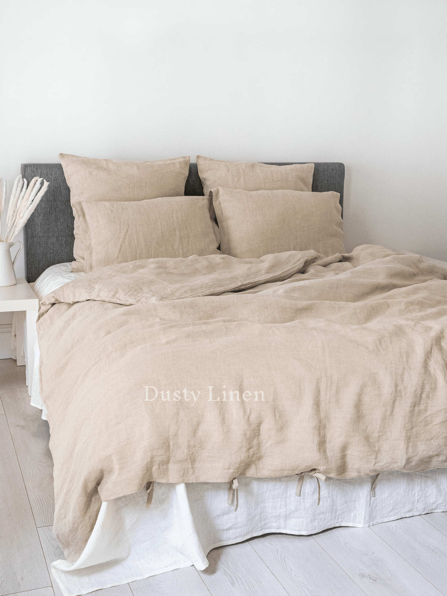 a bed with a beige comforter and pillows