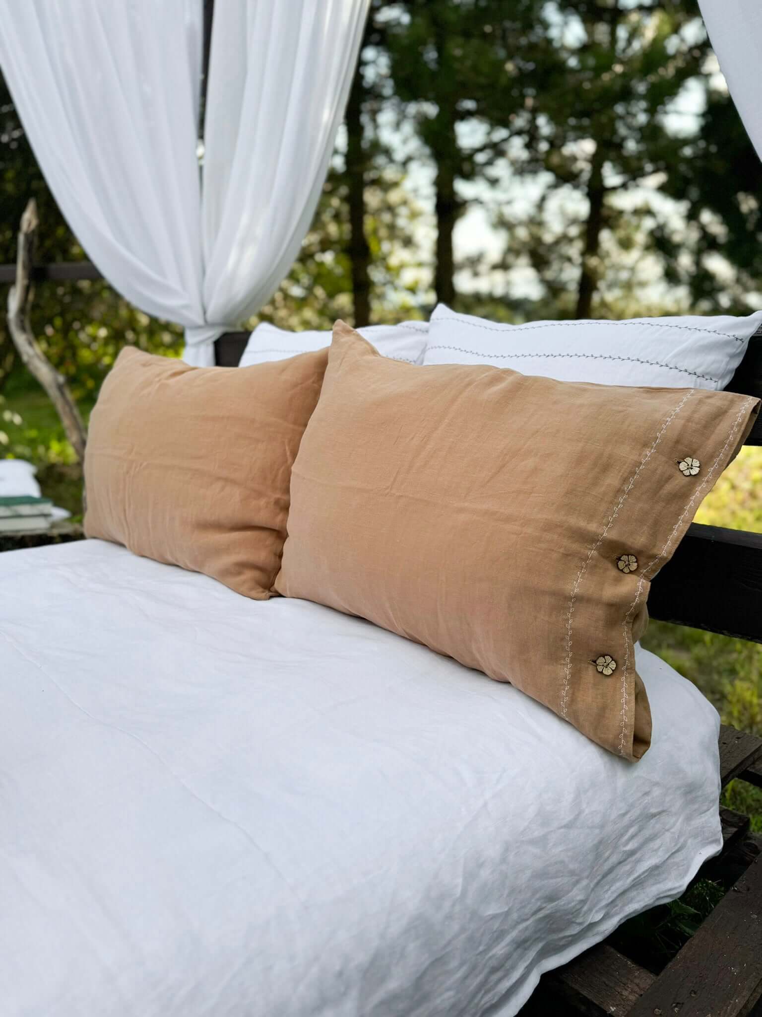 White embroidered linen pillowcases on bed, EU, UK, US size, top view
