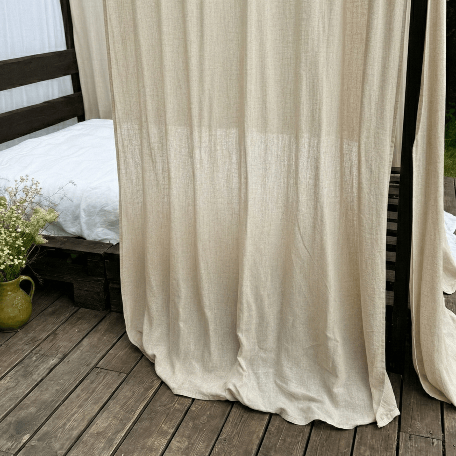 Cream linen canopy curtains styled around a bed with soft natural drape