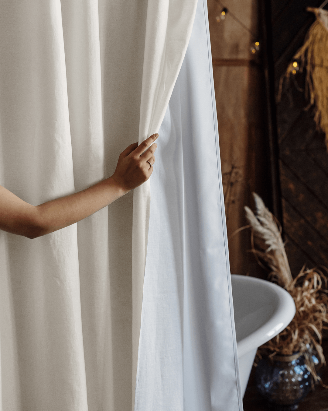 Cream linen shower curtain pulled to one side, showing waterproof lining