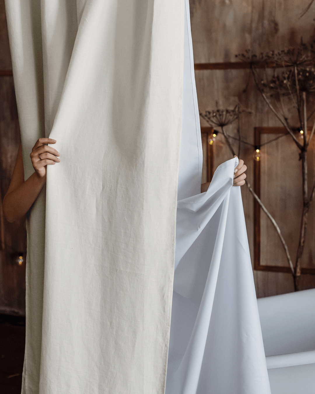 Cream linen shower curtain in bathroom with freestanding bathtub