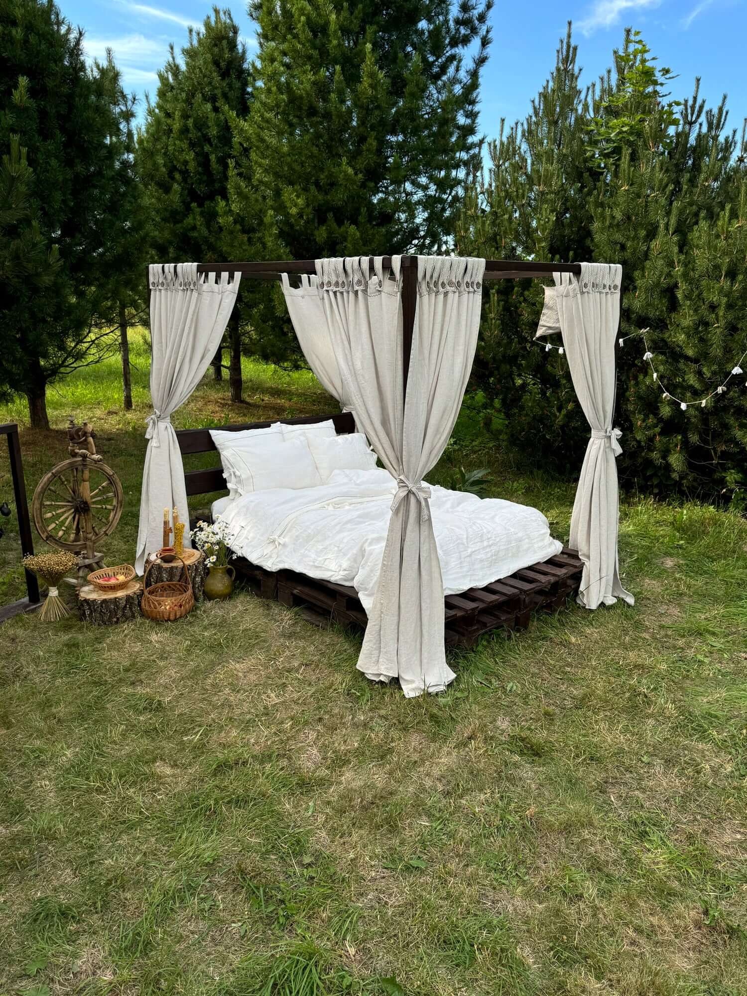 Custom linen canopy curtains on outdoor bed, natural daylight setting